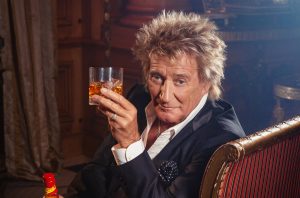 Singer Rod Stewart holding a glass of whisky
