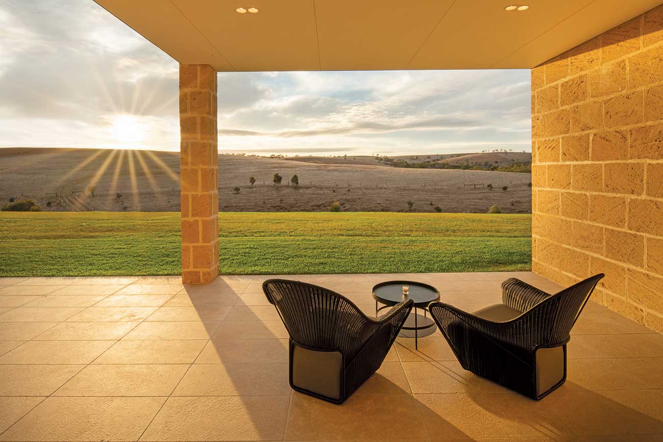 Two outdoor chairs on the terrace of Kingsford the Barossa overlooking the grounds at sunset