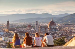 View over the city of Florence with four people sitting with backs to the camera