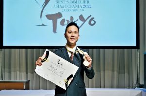 Mason Ng with certificate for winning ASI Best Sommelier of Asia & Oceania 2022, plus award logo on screen in background
