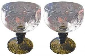 A pair of decorative wine glasses with green stems