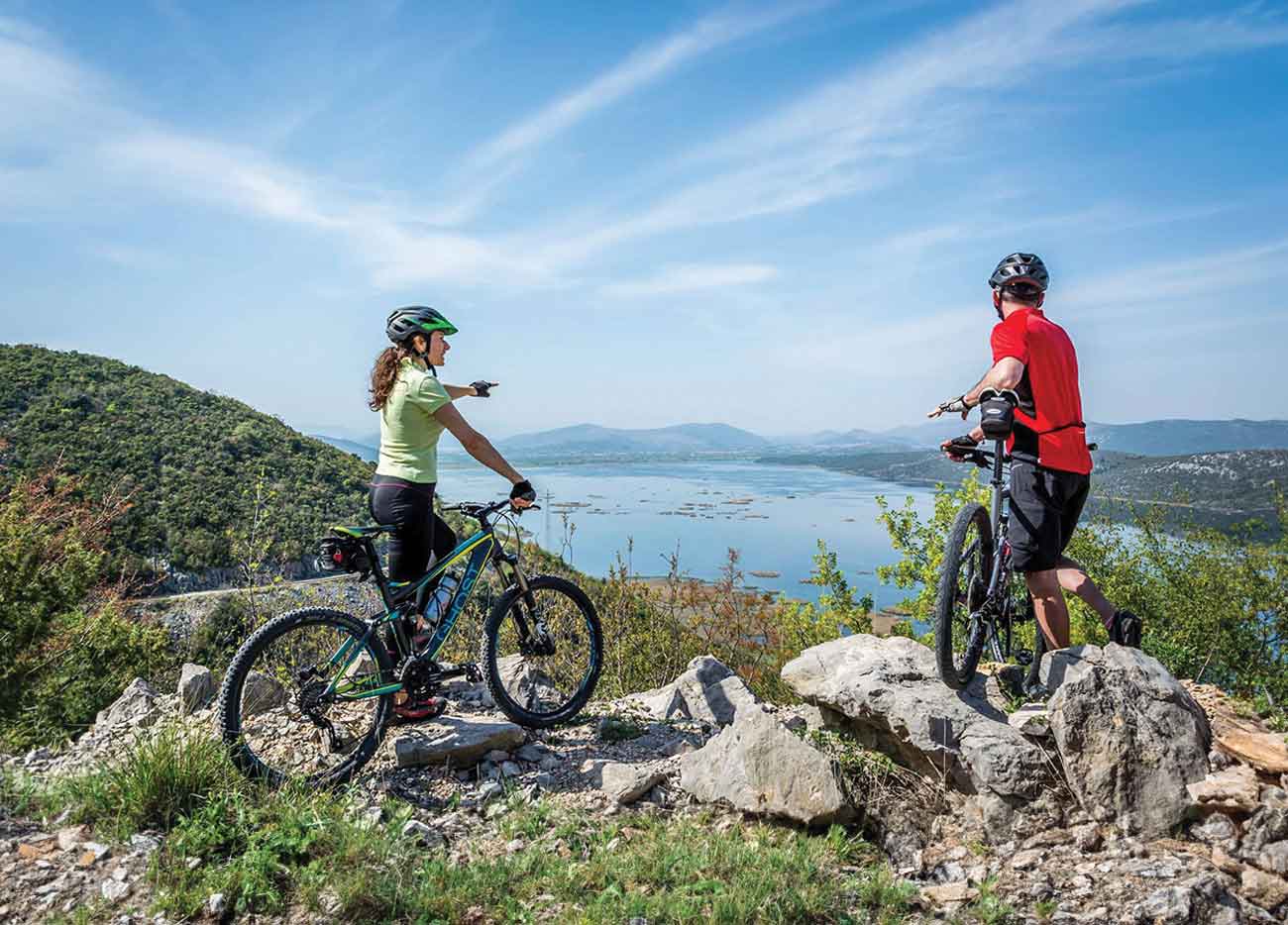 Two people looking over Svitavsko lake on the ?iro bike trail 