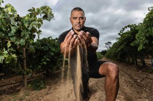 Pauly Vandenbergh holds a handful of soil in a vineyard