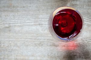 Glass of red wine on wooden table