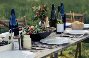Picnic table with salad and bottles of wine