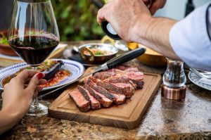 Seasoning steak on a board with