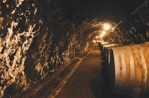 A row of wine barrels in an underground tunnel