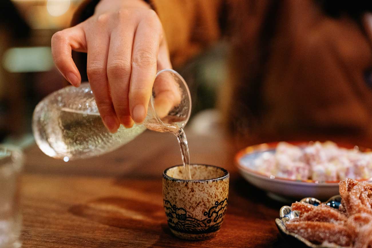 pouring sake and food on a table