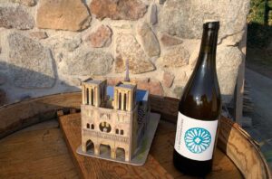 Bottle of Domaine de La Bénisson-Dieu wine and model of Notre-Dame Cathedral