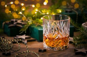 Glass of whisky on table with Christmas decorations