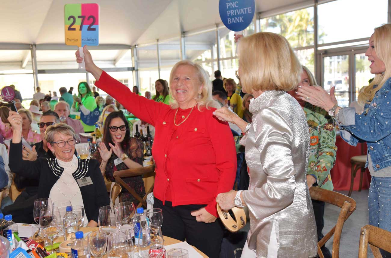 image of a woman holding a paddled at a wine auction