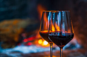 Glasses of wine with fire in background