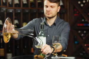 Man pouring glass of white wine